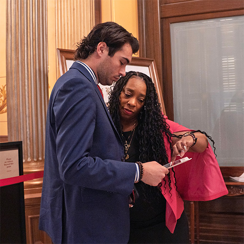 A photo of Daria Ross talking to legislative staff in the Michigan legislature.