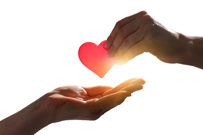 a photo showing a hand holding a heart symbol, placing it in an outstretched hand