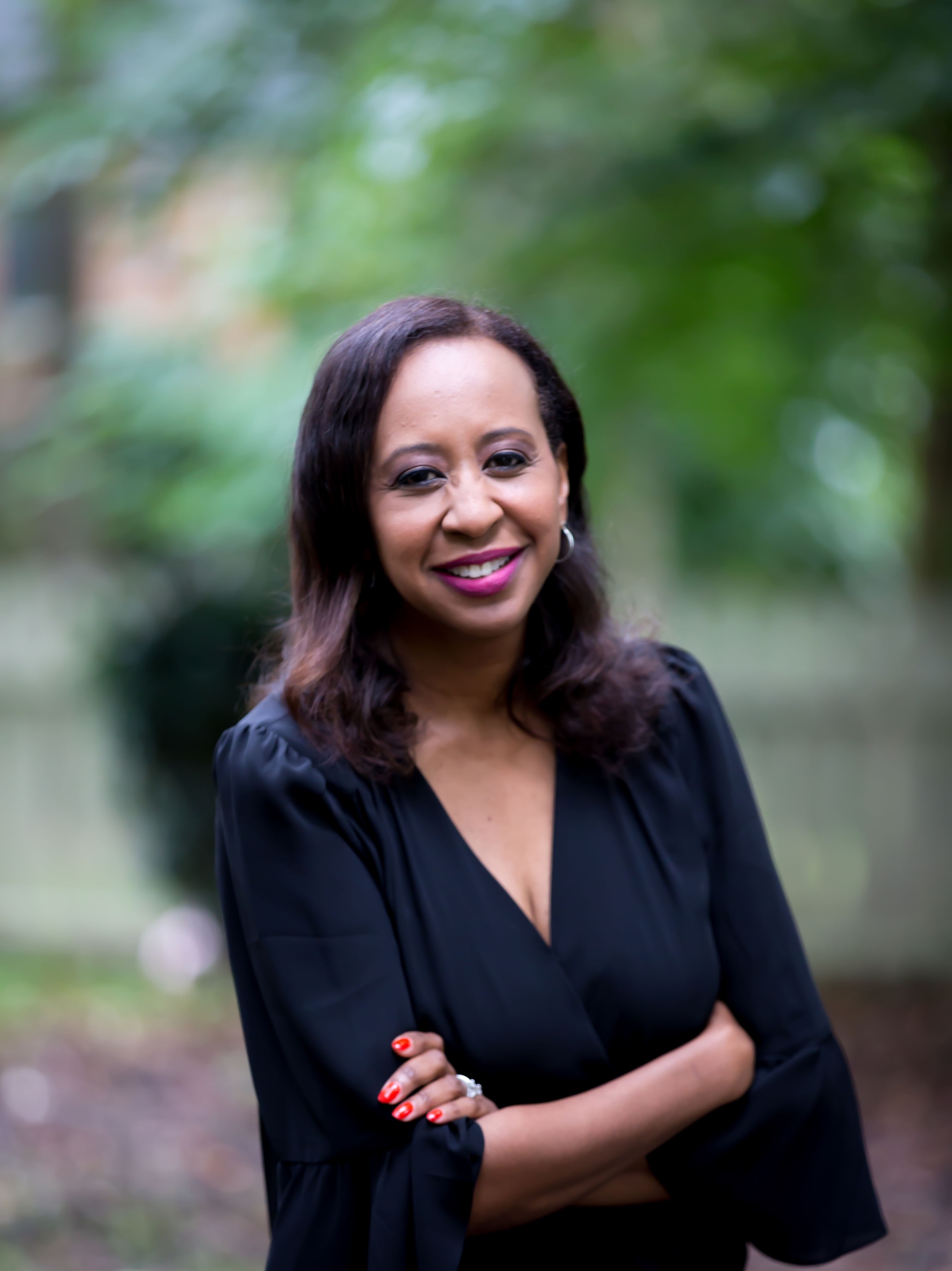Karen Wilson smiling at the camera with her arms crossed.