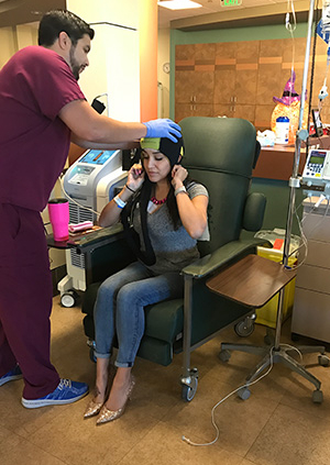 Rebecca Muñoz receiving a cold capping procedure by a nurse practitioner 