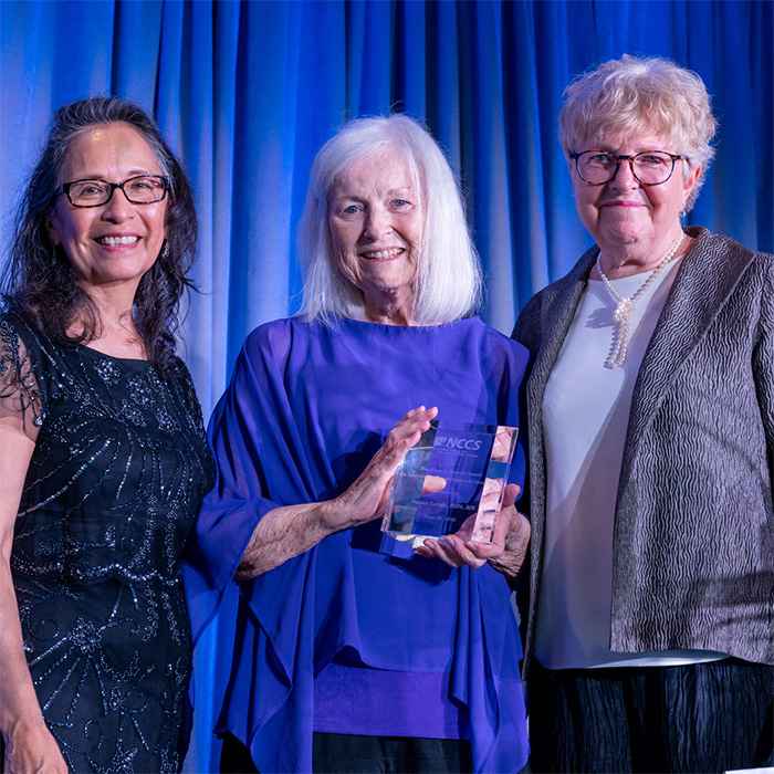 A photo of Susie Leigh receiving the stovall award at the 2025 Igniting Hope reception. Cancer Nation Board Members Ana Maria Lopez and Julia Rowland